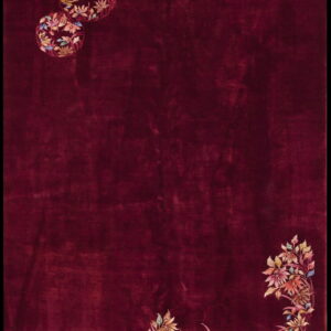 Solid maroon rug with colorful floral arrangements in the upper left and lower right corners.