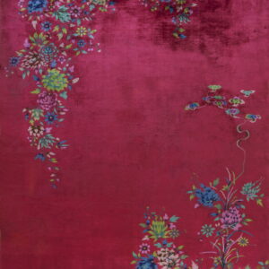 Plush, high-pile magenta rug featuring scattered blue, green, and pink botanical floral corner motifs.