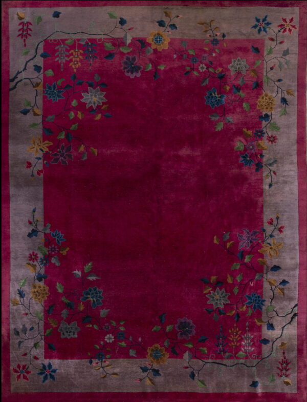 Deep magenta rug with a taupe border featuring multicolored floral and vine motifs framing the center field.