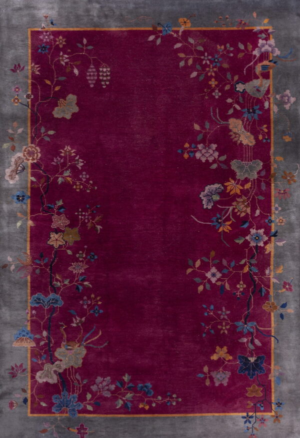 Deep magenta rug featuring a gray border and vibrant floral vines bordering the central field.