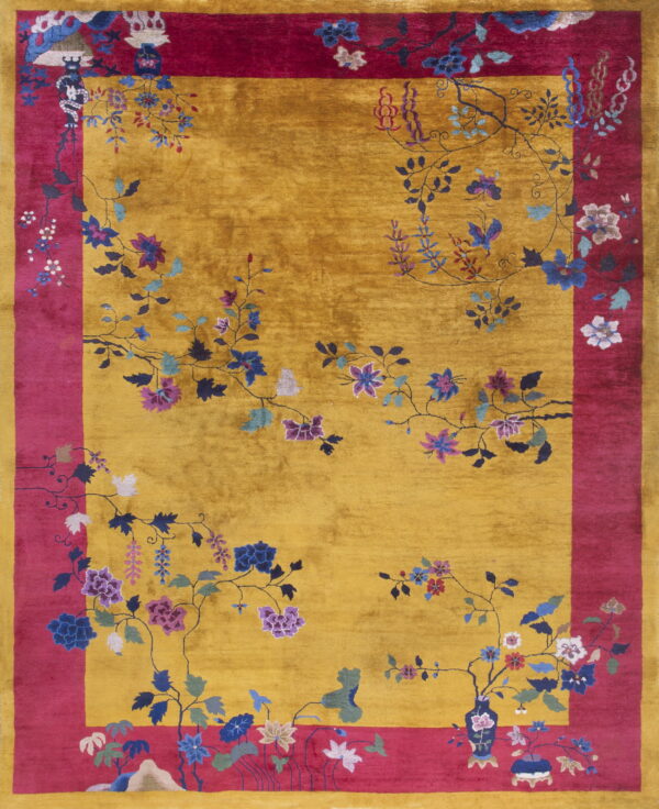 Golden yellow rug with a magenta border featuring multicolored floral and vine motifs.