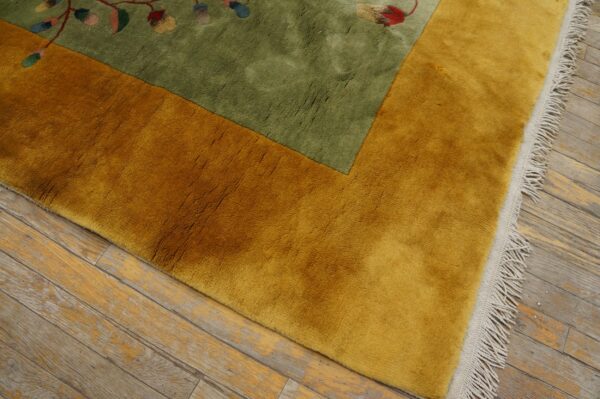 Green and gold high-pile rug featuring a floral pattern, set on weathered wood plank flooring.
