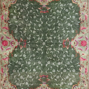 High-pile green rug featuring light green all-over floral pattern and a pale border with pink and red accents.