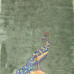 A distressed sage green rug features a large, multicolor peacock design standing on a brown and tan rock.