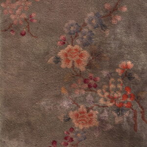 Muted low-pile rug with a distressed dark brown field and faded floral motifs in pink, blue, and rust.