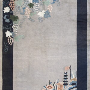 A gray rug with a wide dark blue border, featuring detailed colorful grape vines and a pagoda landscape scene.