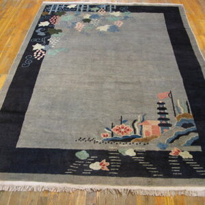Gray pictorial rug with dark navy border features asymmetric vines and a detailed pagoda landscape on wood floor.