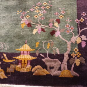Scenic detail of a plush rug showing a gold pagoda and pink flowering trees on sage and purple.