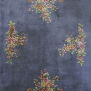 Dark blue rug with a plush texture and scattered multicolored floral arrangements around the border.