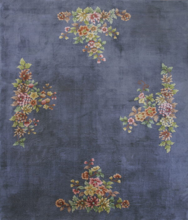 Dark blue rug with a plush texture and scattered multicolored floral arrangements around the border.