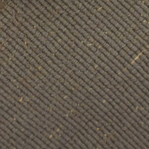 Taupe ribbed rug texture with visible fiber flecks, framed by a contrasting light woven binding.