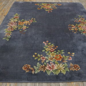 Deep gray rug featuring scattered bouquets of muted yellow, pink, and green flowers on distressed wood floor.