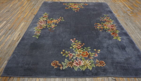 Deep gray rug featuring scattered bouquets of muted yellow, pink, and green flowers on distressed wood floor.