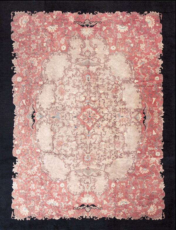 Ornate coral and tan floral rug featuring a large center medallion and an irregular, scalloped edge.