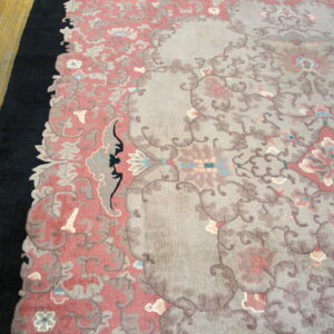 Muted traditional rug in pink, gray, and black on a light brown wood floor.