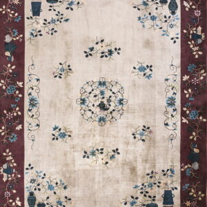 Beige and burgundy traditional rug featuring a blue floral pattern, central motif, and decorative vases.