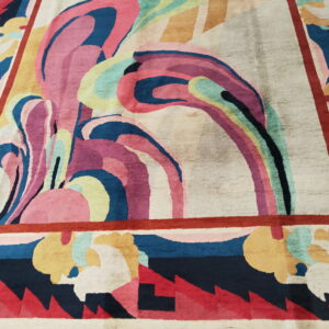 Multicolored rug with a swirling, abstract central motif and a bold geometric border.