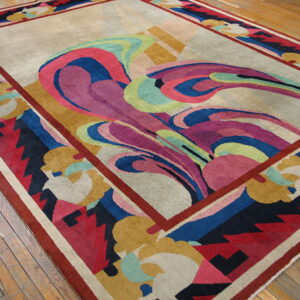 Low-pile rug with flowing magenta, blue, and green abstract patterns on a beige field, resting on wood floors.