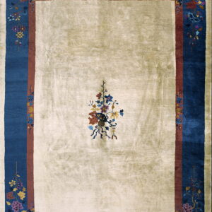 Cream rug with a single central floral motif, surrounded by rust and deep blue borders with complex floral patterns.