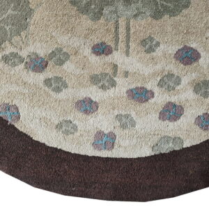 Close-up of a rounded rug section with textured cream pile, a dark brown border, and scattered floral elements.