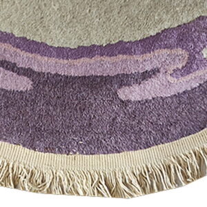 Textured round rug edge showing curved bands of beige and purple pile with a cream woven fringe.