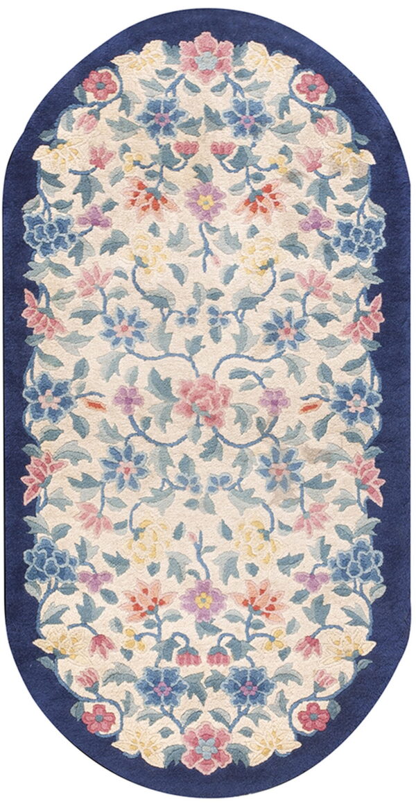 Oval runner rug featuring a symmetrical blue, pink, and yellow floral design bordered by solid navy blue.