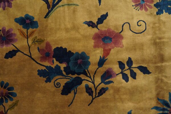 Mustard yellow high-pile rug with dark teal, pink, and purple floral and vine patterns.