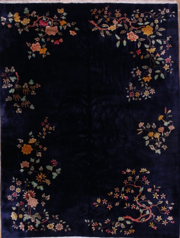 Velvety navy rug with colorful vine and floral patterns surrounding the dark center field.
