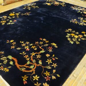 Deep blue high-pile rug featuring scattered golden floral and branch designs on distressed wood planks.