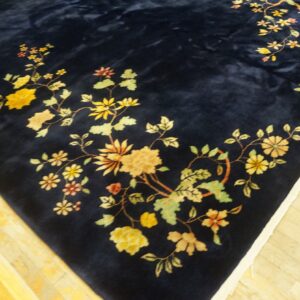Plush navy rug with trailing yellow and green floral vines displayed on bright yellow wood planks.
