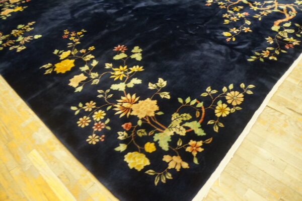 Plush navy rug with trailing yellow and green floral vines displayed on bright yellow wood planks.