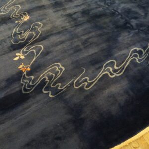 Deep blue plush rug with stylized light gray cloud motifs and floral accents on yellow hardwood floors.