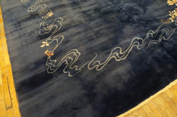 Deep blue plush rug with stylized light gray cloud motifs and floral accents on yellow hardwood floors.
