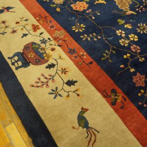 Multicolored floral rug with navy, rust, and tan panels rests on shiny, golden wood plank flooring.