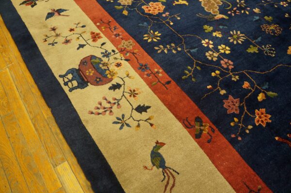 Multicolored floral rug with navy, rust, and tan panels rests on shiny, golden wood plank flooring.