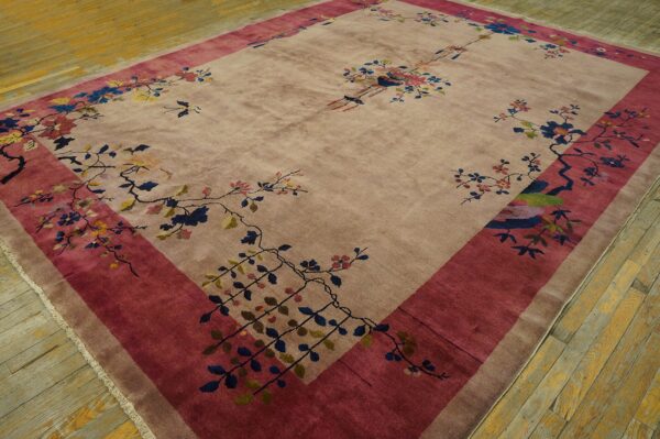 Mauve pile rug with a wide berry border and scattered multicolored botanical motifs on wood floor.
