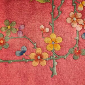 Textured pink rug featuring a multicolored floral and branch design with stylized butterflies.