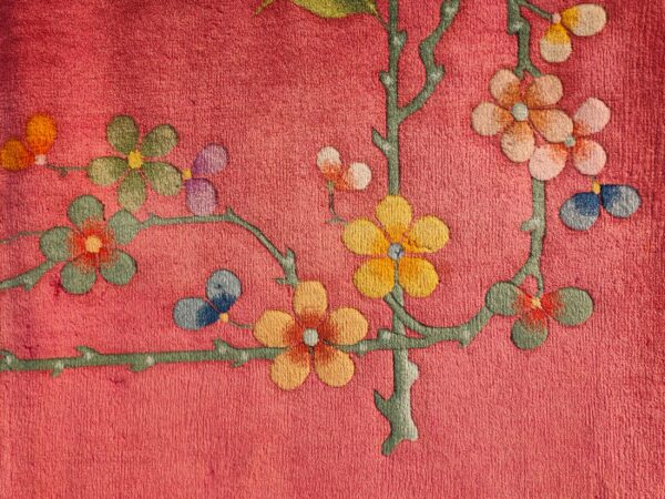 Textured pink rug featuring a multicolored floral and branch design with stylized butterflies.
