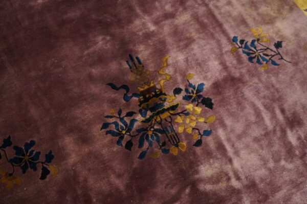 Deep purple pile rug featuring blue and gold ornamental vase and scattered floral vine patterns.