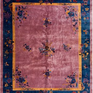 High-pile rug with dusty rose field, teal border, and intricate gold and multicolored floral patterns.