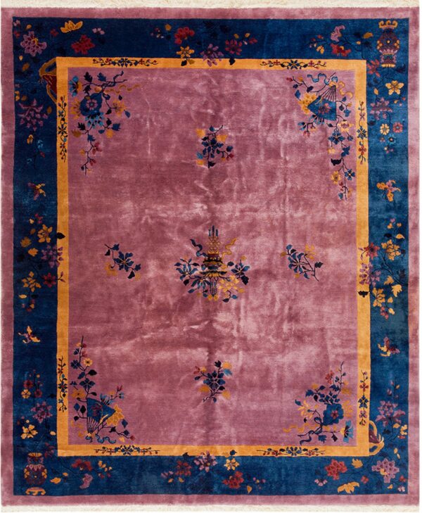 High-pile rug with dusty rose field, teal border, and intricate gold and multicolored floral patterns.
