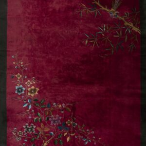 Maroon rug featuring colorful asymmetrical floral vines, bamboo branches, and a bird on a limb.