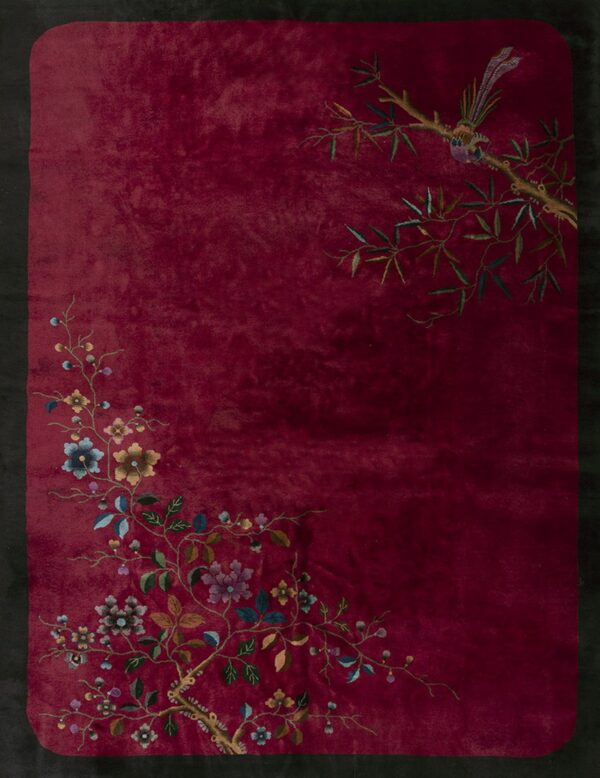 Maroon rug featuring colorful asymmetrical floral vines, bamboo branches, and a bird on a limb.