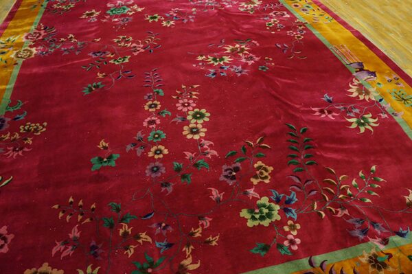 Velvety magenta rug with detailed multicolored floral sprays and a contrasting yellow and green border.