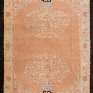 Low-pile rug with a peach field, pale blue accents, and two central floral vase medallions.
