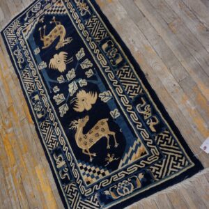 Navy blue and beige rug with animal motifs and geometric borders rests on aged wood planks.