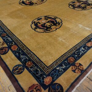 Gold rug with blue dragon medallions and a wide, ornate blue and gold border on wood flooring.