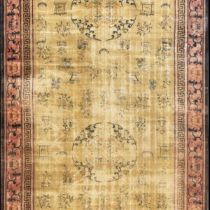 A distressed gold runner rug displays dark symbolic patterns and medallions, framed by pink and black borders.