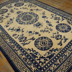 Blue and cream woven rug featuring medallions and elaborate geometric borders on rustic wood flooring.