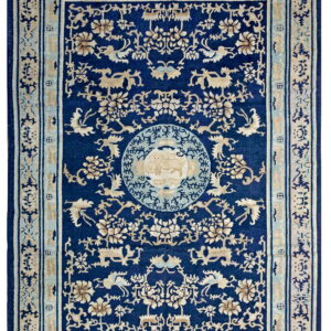 Dark blue rug with detailed beige and pale blue traditional patterns, including a central medallion.